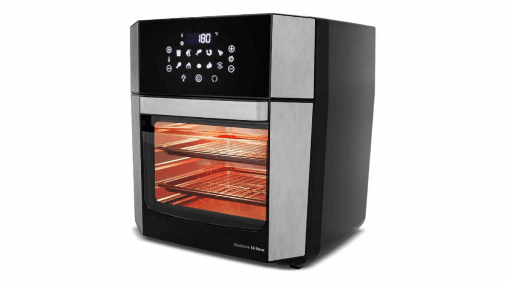 Imagem da Air Fryer Oven Britânia 16L BAF16A com porta removível, painel digital e acessórios internos, destacando sua estrutura 4-em-1 para fritar, assar, grelhar e desidratar alimentos.
