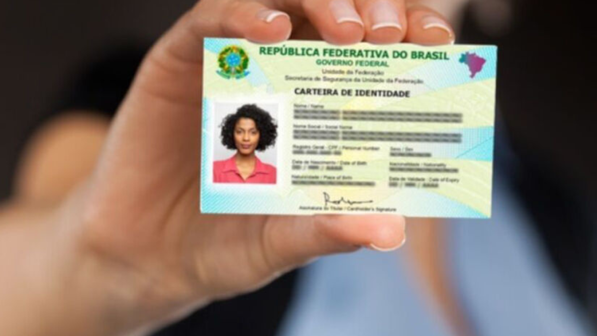 Pessoa segurando a nova Carteira de Identidade Nacional (CIN) emitida em São Paulo, mostrando o documento moderno com QR Code e informações atualizadas.